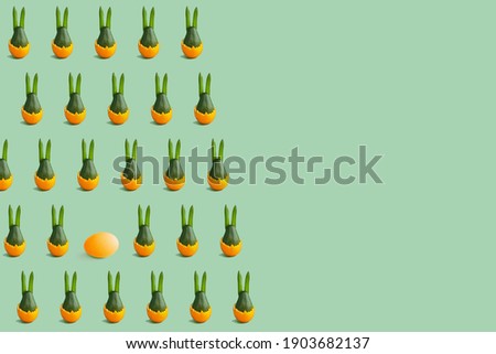 Colorful easter pattern of green avocado bunny in green and orange. Minimal background. Front view. Copy space