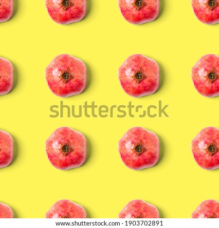 Seamless pattern with red pomegranate fruit on yellow background. Minimal flat lay concept.