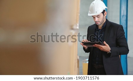 Factory manager using tablet computer in warehouse or factory . Industry and supply chain management concept .