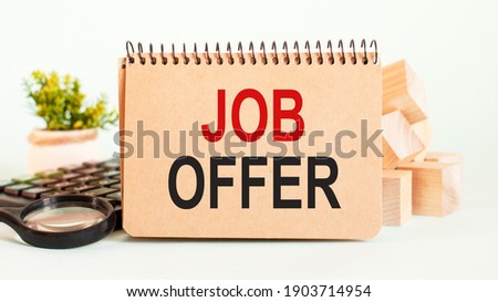 Craft colour notepad with text JOB OFFER. Notepad with calculator, wooden blocks, magnifying glass and green flower. Business concept for online education event written on notepad paper.