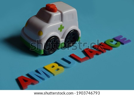 'Ambulance' Wording and An Ambulance Toy isolated with Blue Background