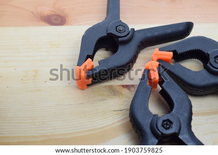 Selective focus of black clamps on wooden Background