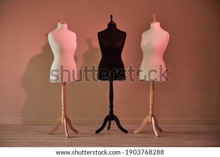 Three mannequins without clothes near the wall Royalty-Free Stock Photo #1903768288