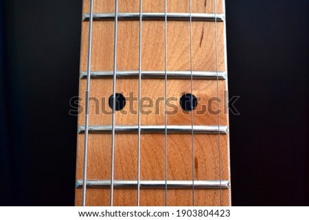 Electric guitar background. Maple fretboard and strings close-up. Royalty-Free Stock Photo #1903804423