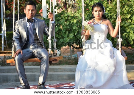 A couple of newlyweds on the swings