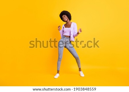 Full body photo of cool positive dark skin lady look empty space toothy smile isolated on yellow color background