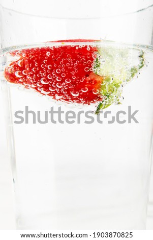Close-up photo of strawberries in carbonated water creating bubbles