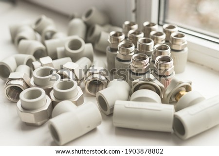 Modern polypropylene water tap with metal thread isolated on white background. Close-up of polypropylene and metal things in warm colors
