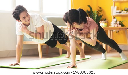 Asian couple doing exercise together at home
 Royalty-Free Stock Photo #1903903825