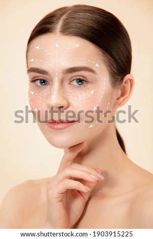 Beautiful female face with lifting up arrows isolated on studio background. Concept of bodycare, cosmetics, skincare, correction surgery, beauty and perfect skin. Flyer for your ad. Antiaging. Royalty-Free Stock Photo #1903915225