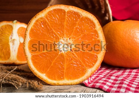 Half and whole fresh oranges on wooden table. Oranges are an excellent source of fiber and vitamin C. Antioxidants in oranges help protect skin from free radical damage and stop premature aging.