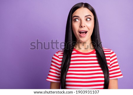 Photo of impressed young lady look side empty space wear striped red shirt isolated violet color background