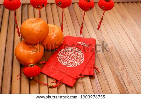 Chinese new year celebration concept.  Money bags, mandarin oranges, and decorations on the wooden table  