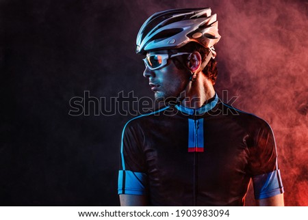Sport background with copyspace. Cyclist. Dramatic colorful close-up portrait. Royalty-Free Stock Photo #1903983094