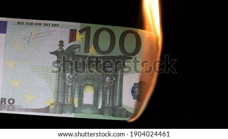 one hundred euros burning on a black