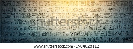 Old Egyptian hieroglyphs on an ancient background. Wide historical background. Ancient Egyptian hieroglyphs as a symbol of the history of the Earth.  Royalty-Free Stock Photo #1904028112