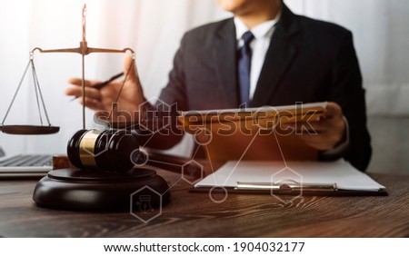 Business and lawyers discussing contract papers with brass scale on desk in office. Law, legal services, advice, justice and law concept  picture with film grain effect