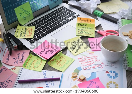 Laptop, notes and office stationery in mess on desk. Overwhelmed with work Royalty-Free Stock Photo #1904060680