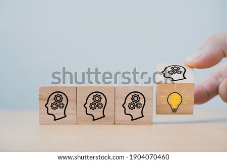 Hand flipping wooden cube block which print screen face with questions mark to lightbulb, creative idea and innovation concept.