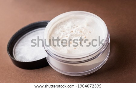 Skin matting powder on a brown background. White powder. Royalty-Free Stock Photo #1904072395