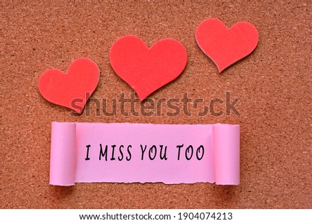 I miss you too label on Torn paper with heart shape on wooden background