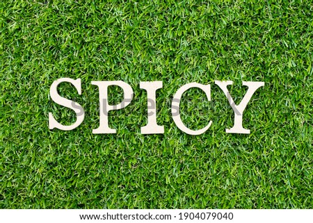 Wood alphabet letter in word spicy on green grass background