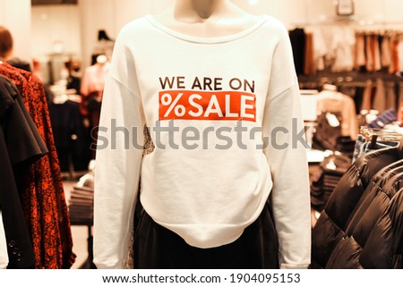 Mannequins in a clothing store in t-shirt with advertising text ‘we are on sale’. Retail shopping.