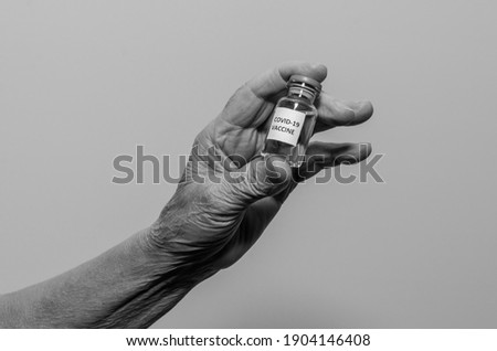 Covid-19 vaccine in the hand of an elderly woman	
