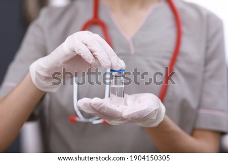 Female doctor with a stethoscope on shoulder holding COVID-19 vaccine. Healthcare And Medical concept. Development and creation of a coronavirus vaccine
