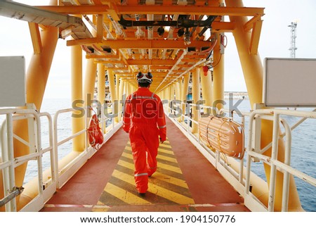 Offshore oil and gas industry and operated by technician petroleum. Worker walking to oil and gas plant for work as routine plan. Maintenance and Operation work scope in oil and gas plant. Royalty-Free Stock Photo #1904150776
