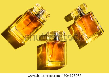 A pattern of woman perfume on the illuminating yellow background, top view, flat lay. Trend color of the year 2021. Mockup of fragrance perfume bottles Royalty-Free Stock Photo #1904173072