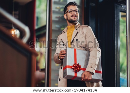 a cheerful young man, with a present