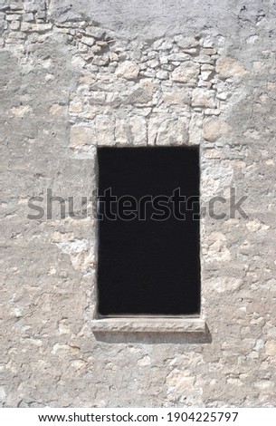 gray stone wall with window cut out for advertising businesses