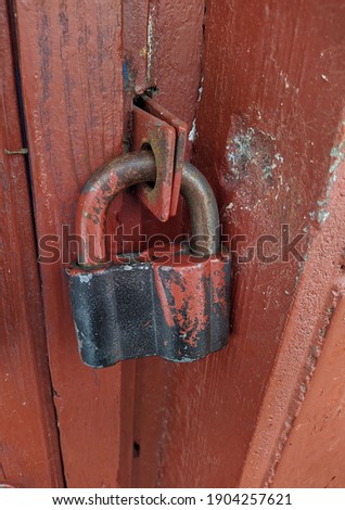 old and large padlock covering a wooden door