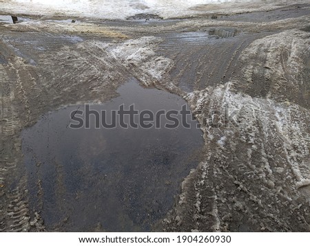 melted snow on a broken and destroyed road