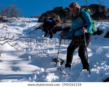 BEAUTIFUL PHOTO BLONDE WOMAN HIKING DOWN A SNOWY SLIDE WITH HER DOG
