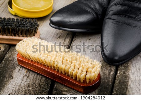 Accessories for the care and cleaning of shoes on a wooden table.