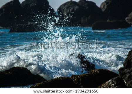 California ocean water splashing on sharp rocks 