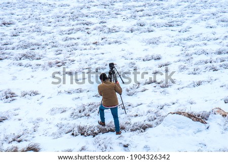 A man photographs a winter landscape