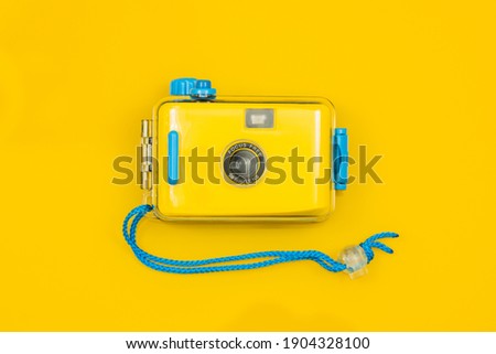 Stylish Yellow-blue camera for underwater photos on a yellow background. 