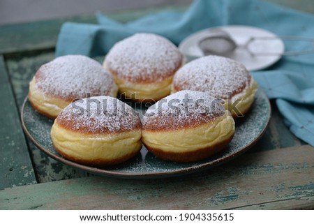Home baked berliner donuts with apricot jam or vanilla cream and sprinkled with sugar powder; delicious traditional Slovenian carnival food; sweet bread dough buns fried with traditional yellow ring
 Royalty-Free Stock Photo #1904335615