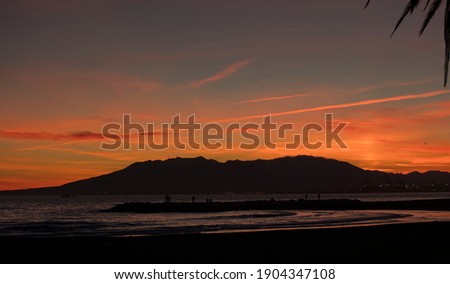sunset with mountains and mediterranean sea, orange yellow sky