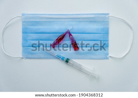mask and syringe on a white background
