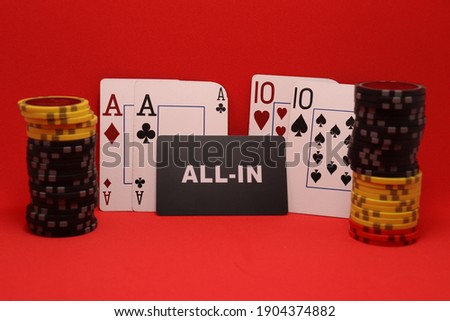 Poker card game with a pair of aces and a pair of 10 and colored chips placed on a red background