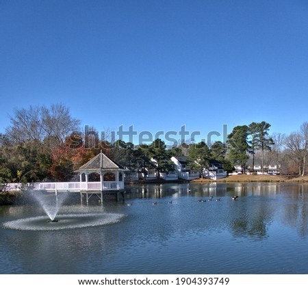 Fountain in a lake with a gazebo in the background