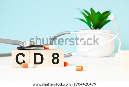 The word CD8 is written on wooden cubes near a stethoscope on a wooden background. Medical concept