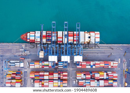 Aerial top view over international containers cargo ship at industrial import-export port prepare to load containers with big container loader ship vessel. global transportation and logistic business. Royalty-Free Stock Photo #1904489608