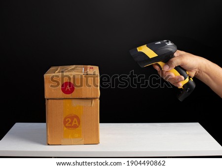 Close up hand hold the barcode scanner scanning the parcel before delivery, logistic dilivery concept
