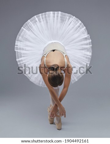 attractive ballerina poses gracefully in the studio on a white background