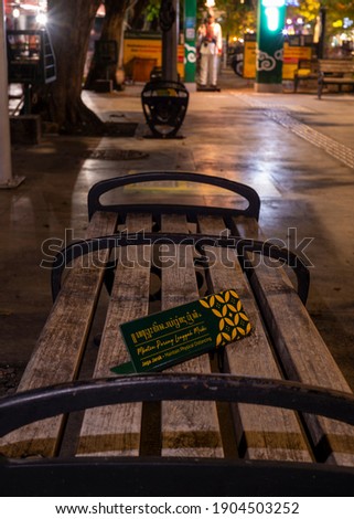 A wooden bench with multi language physical distancing signage seen along the sidewalks of Yogyakarta city 